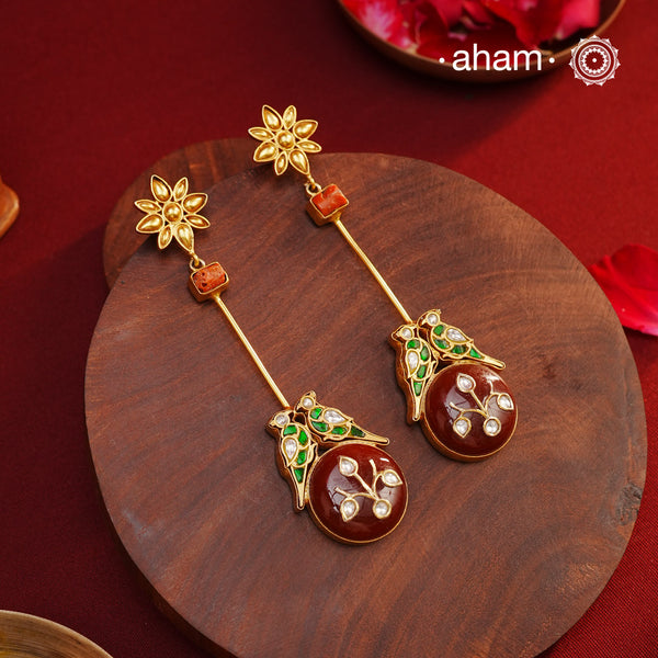 These Double Parrot Gold Polish Silver Earrings feature a unique combo of semi precious stone inlay work, two kundan parrots, raw coral highlights, and a beautiful flower top. Crafted in 92.5 silver with a stunning gold polish, these long shoulderduster earrings will add elegance to any outfit.
