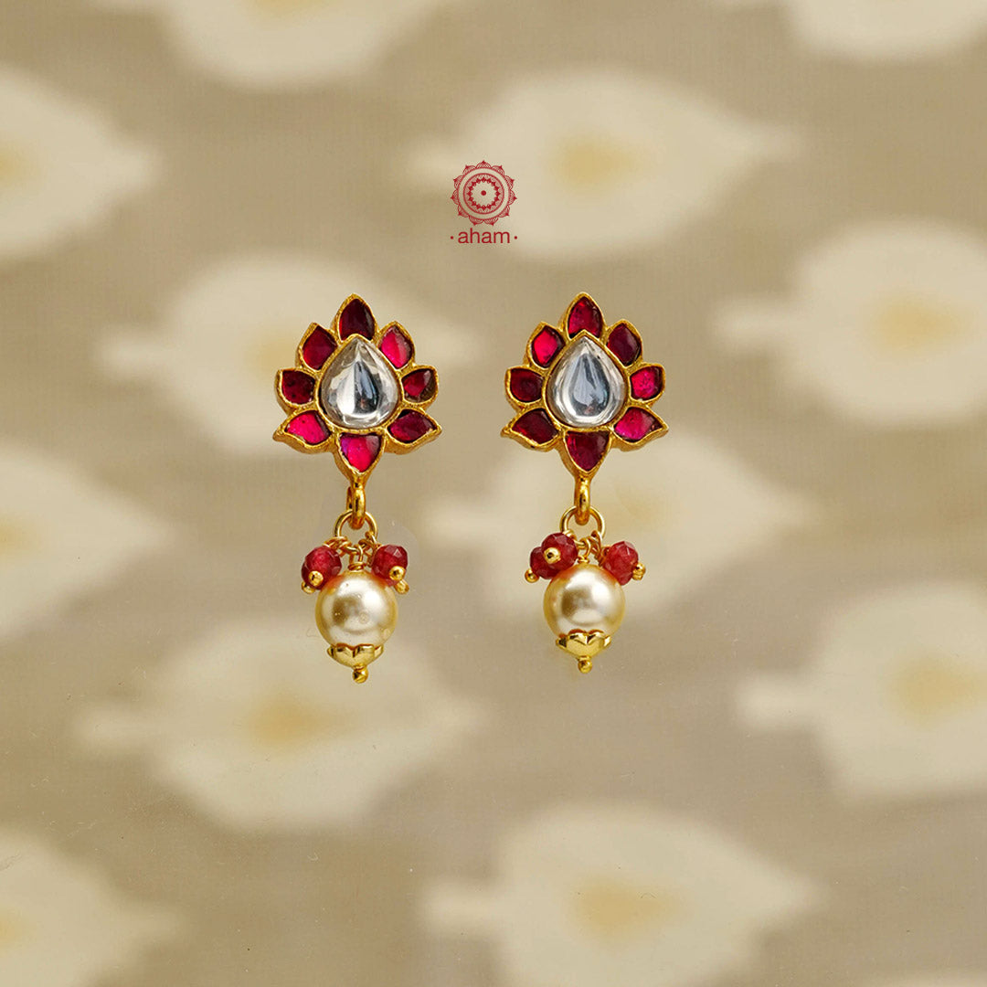 Elegant earrings embellished with red kundan and pearl drop. Handcrafted in 92.5 sterling silver and dipped in gold. Perfect for special occasions and festivities. 