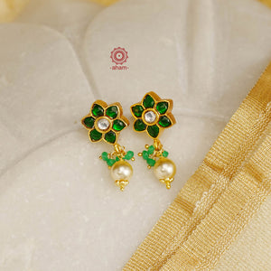 Elegant earrings embellished with green kundan. Handcrafted in 92.5 sterling silver and dipped in gold. Perfect for special occasions and festivities. 