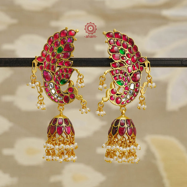 Expertly crafted with 92.5 sterling silver and a stunning gold polish, these Gold Polish Silver Jhumkie earrings boast intricate temple-style designs inspired by ancient craftsmanship. Their exquisite details of kundan and delicate pearls make them heirloom pieces that can be cherished for years to come. 