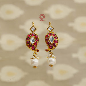 Expertly crafted with 92.5 silver and a lustrous gold polish, these traditional Ambi earrings feature a stunning kudan highlight and a delicate pearl drop. Wear it at festivities and special occassions. 