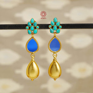 Elevate your style with our Gold Polish Silver Earrings. Handcrafted in silver, these stunning earrings feature a gorgeous combination of turquoise and gold tones, accented with a mesmerizing blue glass center. Add a touch of elegance to any outfit with these unique and beautifully designed earrings.
