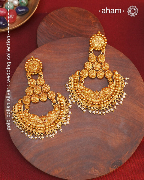 Statement gold polish chandbali earring with nakshi work. Handcrafted using traditional methods in 92.5 sterling silver with dangling cultured pearls. Pair these with your ethnic outfits this festive season to ace your look.