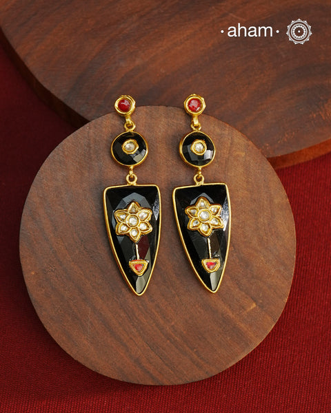 These Black Onyx Gold Polish Silver Earrings feature exquisite kundan inlay work, blending traditional craftsmanship with contemporary style. Perfectly suited for Indo-Western ensembles, they add a touch of elegance and sophistication to your look. Crafted with attention to detail, these earrings enhance your outfit with their rich black onyx contrast and subtle gold polish, making them a versatile accessory for special occasions.