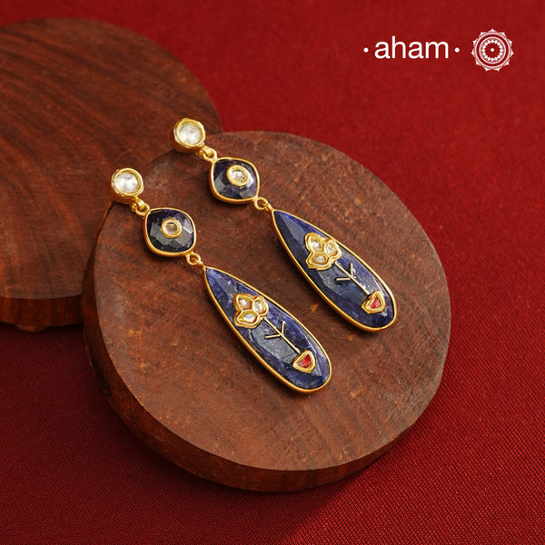 These Lapiz Gold Polish Silver Earrings feature exquisite kundan inlay work, blending traditional craftsmanship with contemporary style. Perfectly suited for Indo-Western ensembles, they add a touch of elegance and sophistication to your look. Crafted with attention to detail, these earrings enhance your outfit with their deep blue contrast and subtle gold polish, making them a versatile accessory for special occasions.