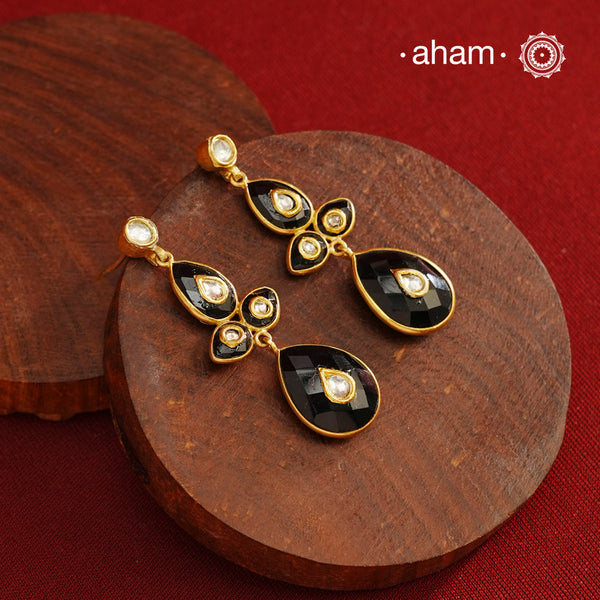 These Black Onyx Gold Polish Silver Earrings feature exquisite kundan inlay work, blending traditional craftsmanship with contemporary style. Perfectly suited for Indo-Western ensembles, they add a touch of elegance and sophistication to your look. Crafted with attention to detail, these earrings enhance your outfit with their rich black onyx contrast and subtle gold polish, making them a versatile accessory for special occasions.