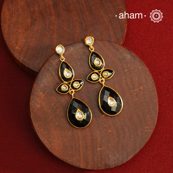 These Black Onyx Gold Polish Silver Earrings feature exquisite kundan inlay work, blending traditional craftsmanship with contemporary style. Perfectly suited for Indo-Western ensembles, they add a touch of elegance and sophistication to your look. Crafted with attention to detail, these earrings enhance your outfit with their rich black onyx contrast and subtle gold polish, making them a versatile accessory for special occasions.
