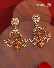 These Festive Gold Polish Silver Earrings feature traditional craftsmanship from South India in a modern design. Made with 92.5 silver, these earrings are adorned with kemp work and pearls, giving them a touch of elegance. Dipped in gold polish for added luster.