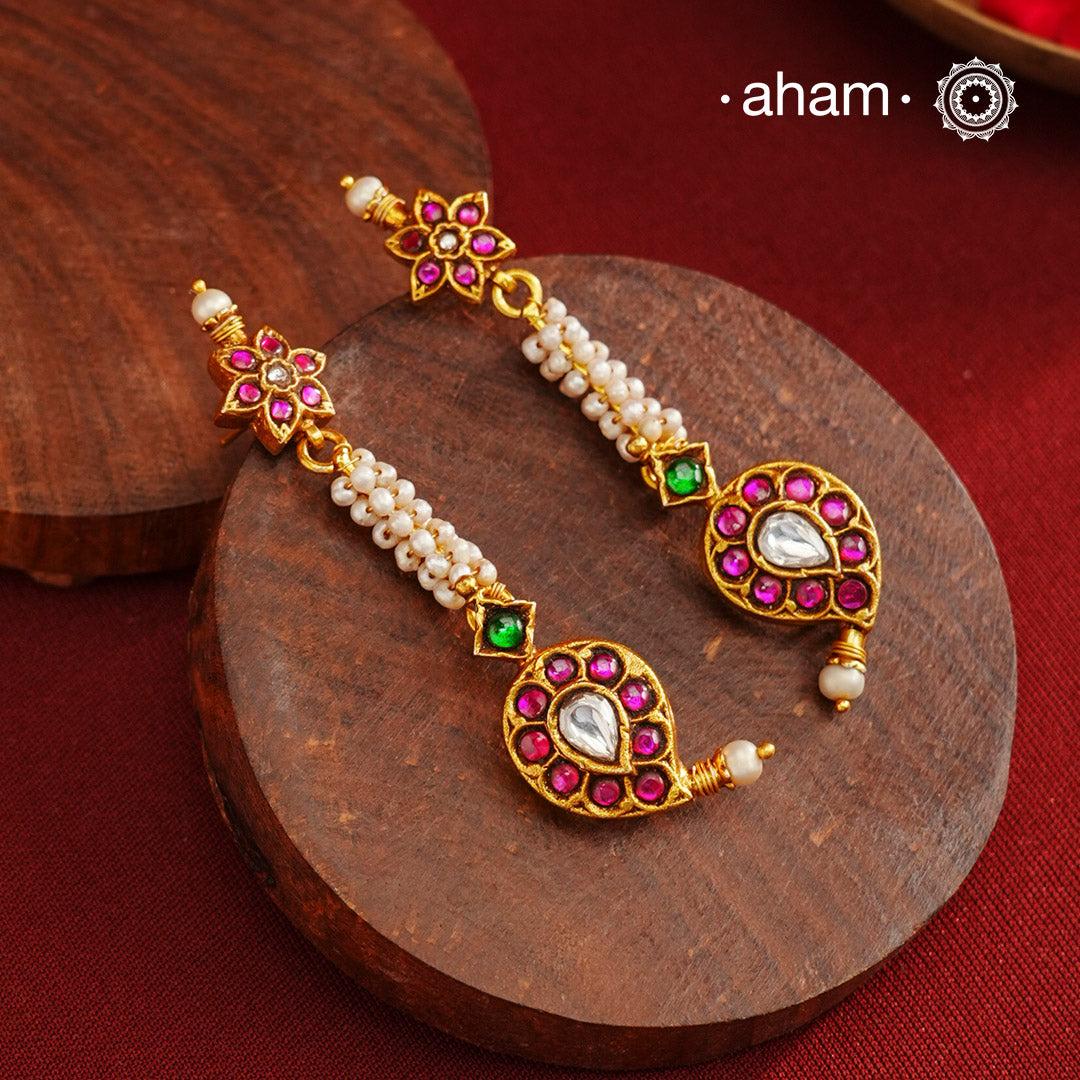 These Gold Polish Paisley Silver Earrings beautifully reflect the elegance of South Indian traditional design, featuring delicate kemp and pearl work. Crafted from 92.5% pure silver with a fine gold polish, it is a graceful and timeless design that complements your style effortlessly.