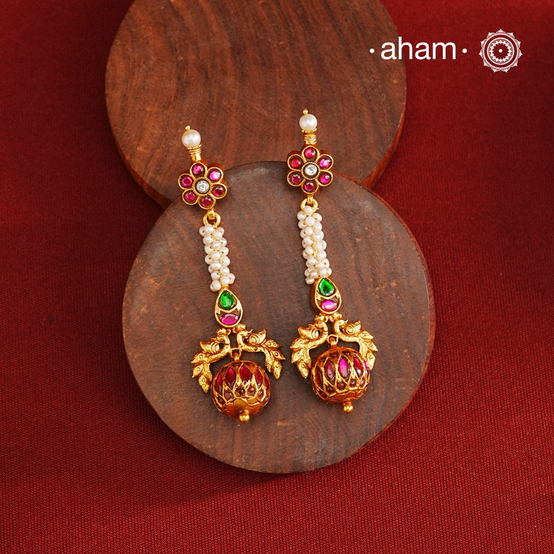 These Gold Polish Peacock Silver Earrings beautifully reflect the elegance of South Indian traditional design, featuring delicate kemp and pearl work. Crafted from 92.5% pure silver with a fine gold polish, it is a graceful and timeless design that complements your style effortlessly.