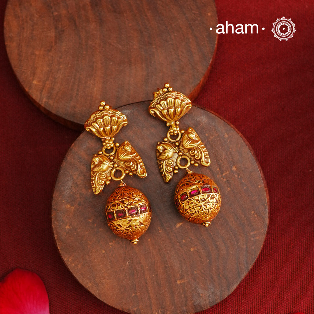 These Gold Polish Peacock Silver Earrings beautifully reflect the elegance of South Indian traditional design, featuring delicate kemp work. Crafted from 92.5% pure silver with a fine gold polish, it is a graceful and timeless design that complements your style effortlessly.