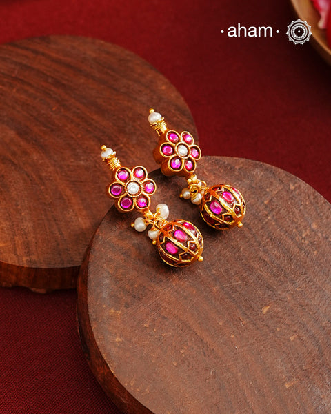 These elegant earrings feature intricate kemp work, meticulously crafted from 92.5% silver and enhanced with a subtle gold polish. Small pearls add delicate highlights, enhancing their traditional charm. Designed to complement a variety of traditional outfits, they blend classic artistry with versatile wearability.