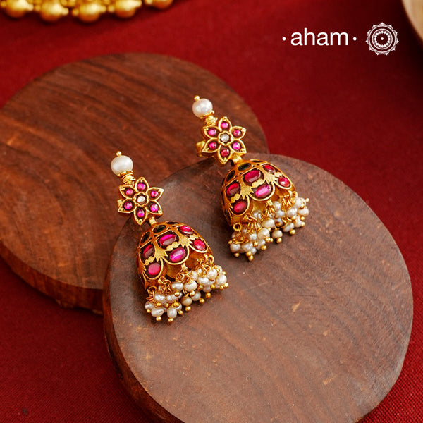 Expertly crafted in 92.5% sterling silver with a fine gold polish, these jhumkies showcase flawless Kemp stone work intricately laced with delicate pearls. This combination highlights traditional craftsmanship while offering a sophisticated accessory that complements both classic and contemporary styles.