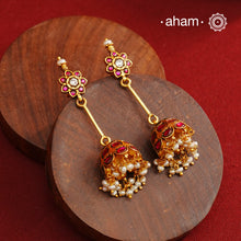 Jhumkie earring showcasing exquisite Kemp work, meticulously crafted in 92.5% silver with a fine gold polish finish. Adorned with delicate pearls, they blend classic elegance with expert craftsmanship, making them a timeless addition to any jewelry collection.
