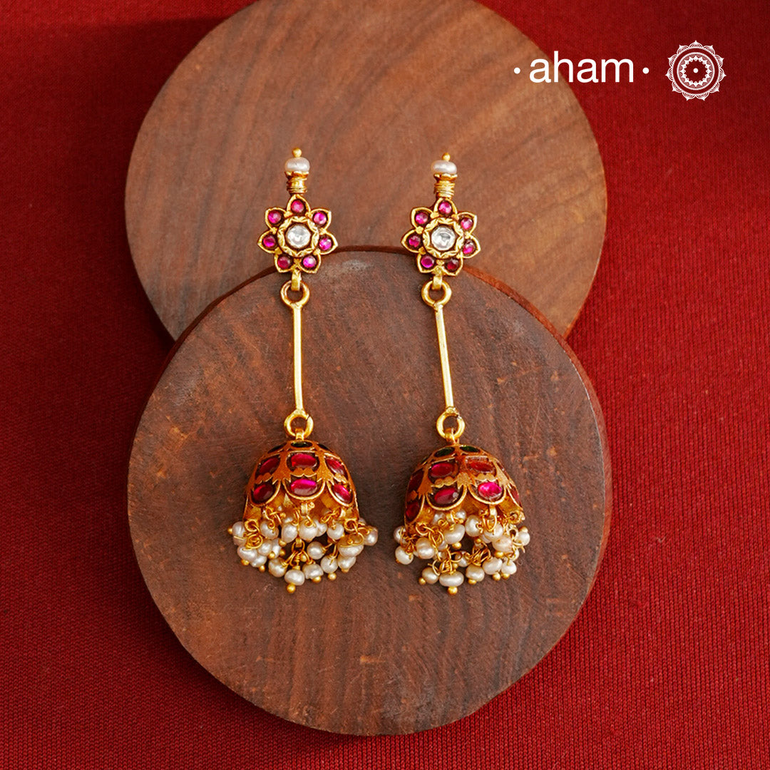Jhumkie earring showcasing exquisite Kemp work, meticulously crafted in 92.5% silver with a fine gold polish finish. Adorned with delicate pearls, they blend classic elegance with expert craftsmanship, making them a timeless addition to any jewelry collection.