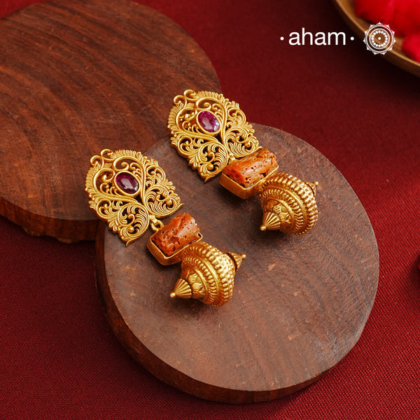 Gold Polish Silver Earrings that blend traditional South Indian artistry with a contemporary touch. Featuring intricate lattice work on the top and a striking coral centerpiece, they are accented with subtle kemp highlight. Crafted from 92.5% pure silver and finished with a rich gold polish, these earrings offer both elegance and cultural heritage in a refined design.