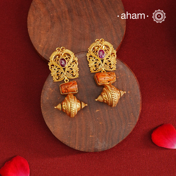 Gold Polish Silver Earrings that blend traditional South Indian artistry with a contemporary touch. Featuring intricate lattice work on the top and a striking coral centerpiece, they are accented with subtle kemp highlight. Crafted from 92.5% pure silver and finished with a rich gold polish, these earrings offer both elegance and cultural heritage in a refined design.