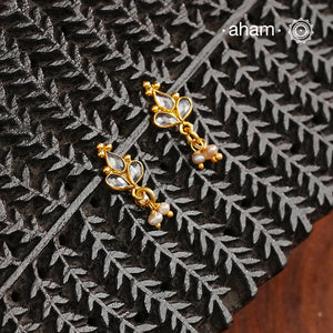Mini earrings crafted in silver and fine gold polish. The earrings are set with zircon stones and pearl drops.