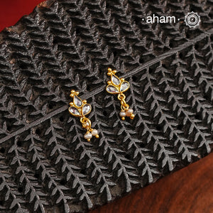 Mini earrings crafted in silver and fine gold polish. The earrings are set with zircon stones and pearl drops.
