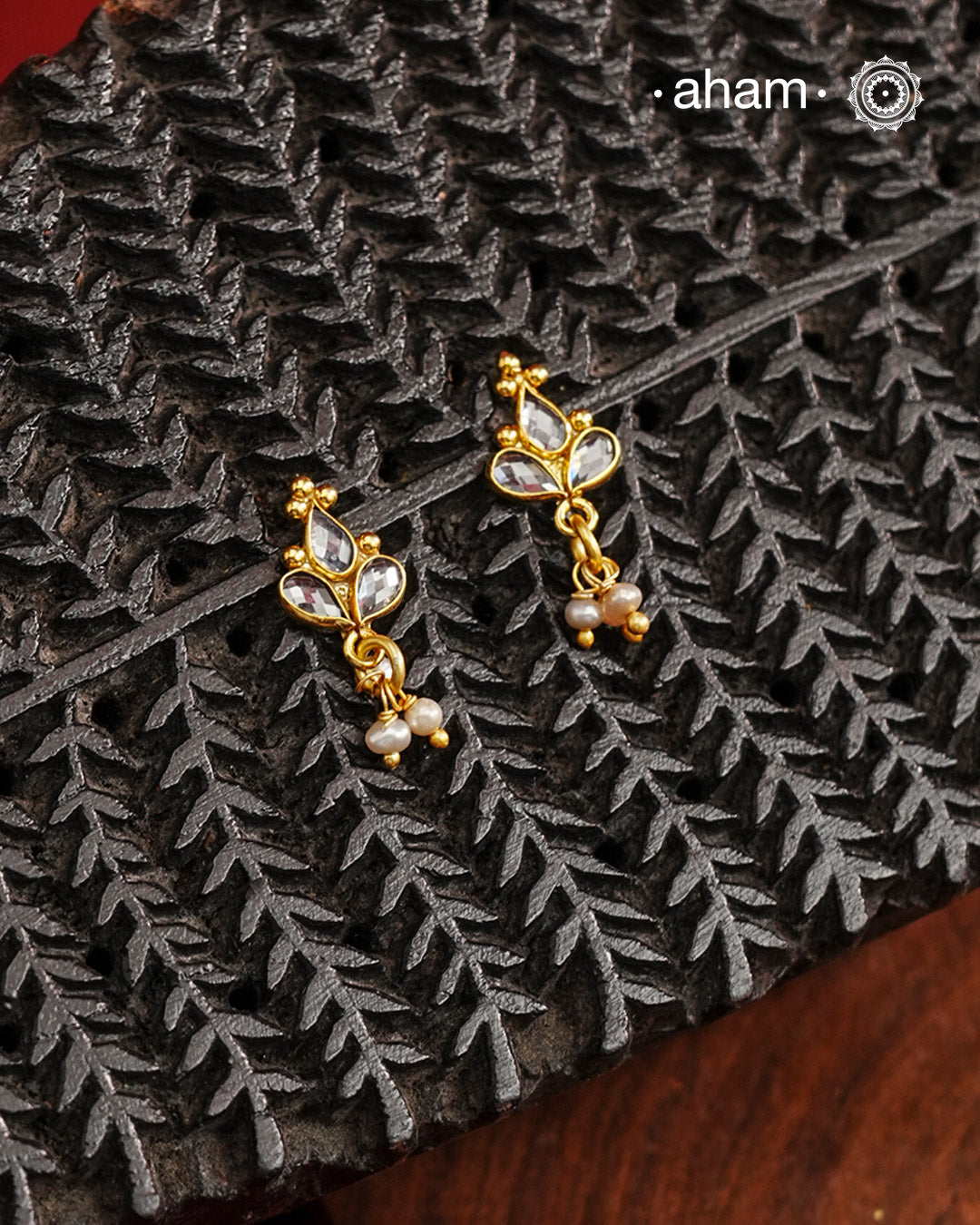 Mini earrings crafted in silver and fine gold polish. The earrings are set with zircon stones and pearl drops.