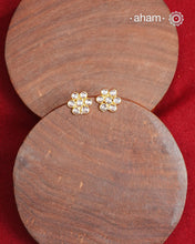 Little zircon studded earrings crafted in silver with gold polish.&nbsp;