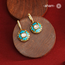 These elegant two-sided hoop earrings offer timeless style with a modern twist. Crafted from 92.5% silver and enhanced with a gold polish, they feature red kundan stones on one side and soothing feroza on the other. This unique design provides versatile wear options, allowing you to effortlessly switch between vibrant and subtle looks while enjoying the quality of fine silver craftsmanship.