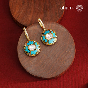 These elegant two-sided hoop earrings offer timeless style with a modern twist. Crafted from 92.5% silver and enhanced with a gold polish, they feature red kundan stones on one side and soothing feroza on the other. This unique design provides versatile wear options, allowing you to effortlessly switch between vibrant and subtle looks while enjoying the quality of fine silver craftsmanship.