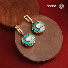 These elegant two-sided hoop earrings offer timeless style with a modern twist. Crafted from 92.5% silver and enhanced with a gold polish, they feature red kundan stones on one side and soothing feroza on the other. This unique design provides versatile wear options, allowing you to effortlessly switch between vibrant and subtle looks while enjoying the quality of fine silver craftsmanship.