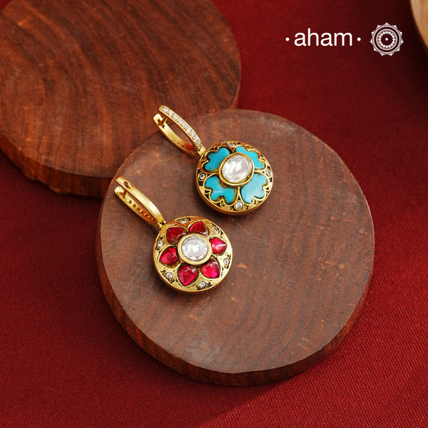 These elegant two-sided hoop earrings offer timeless style with a modern twist. Crafted from 92.5% silver and enhanced with a gold polish, they feature red kundan stones on one side and soothing feroza on the other. This unique design provides versatile wear options, allowing you to effortlessly switch between vibrant and subtle looks while enjoying the quality of fine silver craftsmanship.