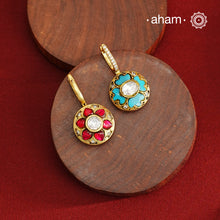 These elegant two-sided hoop earrings offer timeless style with a modern twist. Crafted from 92.5% silver and enhanced with a gold polish, they feature red kundan stones on one side and soothing feroza on the other. This unique design provides versatile wear options, allowing you to effortlessly switch between vibrant and subtle looks while enjoying the quality of fine silver craftsmanship.