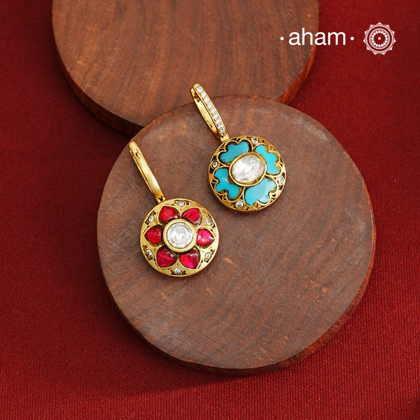 These elegant two-sided hoop earrings offer timeless style with a modern twist. Crafted from 92.5% silver and enhanced with a gold polish, they feature red kundan stones on one side and soothing feroza on the other. This unique design provides versatile wear options, allowing you to effortlessly switch between vibrant and subtle looks while enjoying the quality of fine silver craftsmanship.
