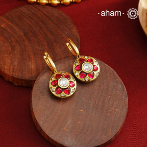 These elegant two-sided hoop earrings offer timeless style with a modern twist. Crafted from 92.5% silver and enhanced with a gold polish, they feature red kundan stones on one side and soothing feroza on the other. This unique design provides versatile wear options, allowing you to effortlessly switch between vibrant and subtle looks while enjoying the quality of fine silver craftsmanship.