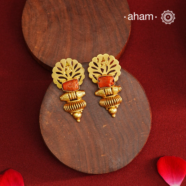 These Gold Polish Peacock Silver Earrings showcase exquisite cut work detailing, centered with a vibrant coral stone. Blending traditional motifs with a contemporary twist, they are meticulously crafted in 92.5% sterling silver and finished with a rich gold polish, offering both elegance and durability. Perfect for those seeking a refined accessory that honors heritage while embracing modern style.