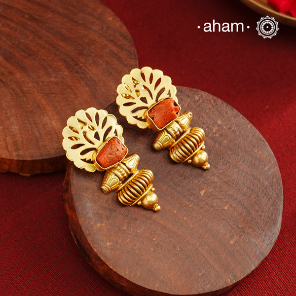 These Gold Polish Peacock Silver Earrings showcase exquisite cut work detailing, centered with a vibrant coral stone. Blending traditional motifs with a contemporary twist, they are meticulously crafted in 92.5% sterling silver and finished with a rich gold polish, offering both elegance and durability. Perfect for those seeking a refined accessory that honors heritage while embracing modern style.