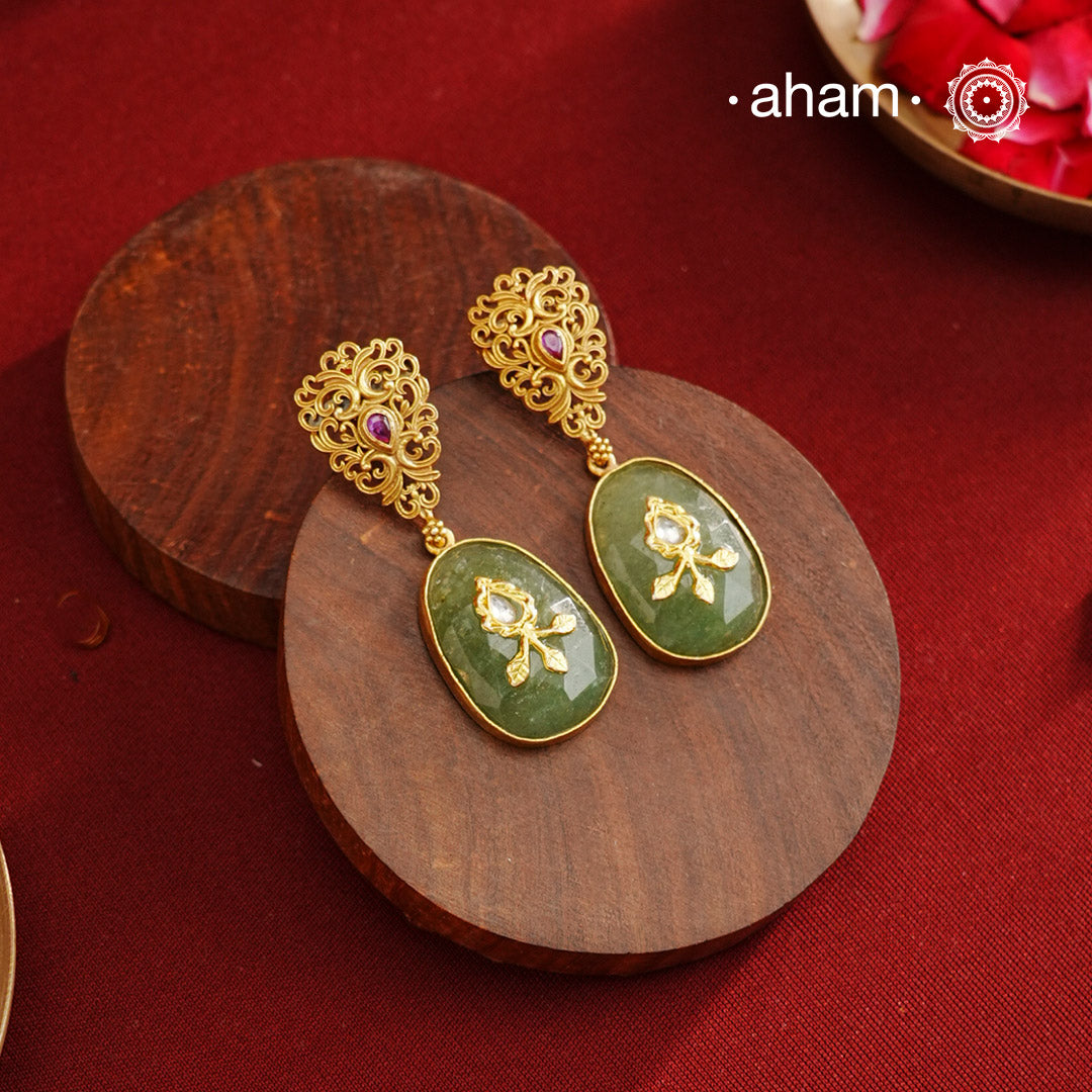 These Gold Polish Silver Earrings feature exquisite lattice-like detailing with a striking kemp stone centerpiece and a serene green drop stone accented by intricate inlay work. Crafted from 92.5% silver and finished with a luxurious gold polish, they seamlessly combine contemporary design with timeless traditional elegance.