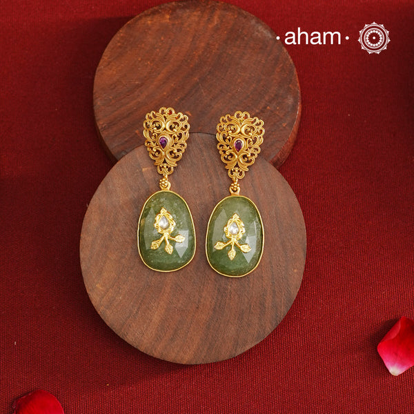 These Gold Polish Silver Earrings feature exquisite lattice-like detailing with a striking kemp stone centerpiece and a serene green drop stone accented by intricate inlay work. Crafted from 92.5% silver and finished with a luxurious gold polish, they seamlessly combine contemporary design with timeless traditional elegance.
