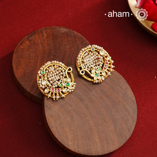 These Nath-inspired silver studs feature intricate kundan and pearl detailing, finished with a rich gold polish. Crafted from 92.5% pure silver, they blend traditional elegance with durability, making them an ideal accessory for festive occasions. Their refined design complements ethnic attire, adding a touch of sophistication to your celebration ensemble.
