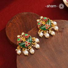 Statement gold polish earring from our heritage collection with a beautiful green stone center and pearl drops. Handcrafted using traditional methods in 92.5 sterling silver with gold polish. Pair these with your ethnic outfits this festive season to ace your look.