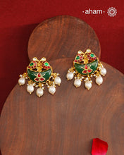 Statement gold polish earring from our heritage collection with a beautiful green stone center and pearl drops. Handcrafted using traditional methods in 92.5 sterling silver with gold polish. Pair these with your ethnic outfits this festive season to ace your look.