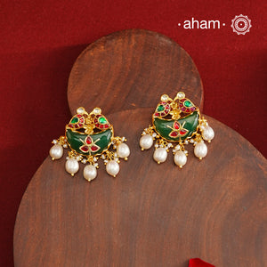Statement gold polish earring from our heritage collection with a beautiful green stone center and pearl drops. Handcrafted using traditional methods in 92.5 sterling silver with gold polish. Pair these with your ethnic outfits this festive season to ace your look.