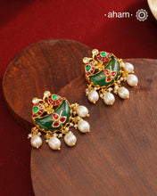 Statement gold polish earring from our heritage collection with a beautiful green stone center and pearl drops. Handcrafted using traditional methods in 92.5 sterling silver with gold polish. Pair these with your ethnic outfits this festive season to ace your look.