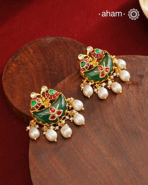 Statement gold polish earring from our heritage collection with a beautiful green stone center and pearl drops. Handcrafted using traditional methods in 92.5 sterling silver with gold polish. Pair these with your ethnic outfits this festive season to ace your look.