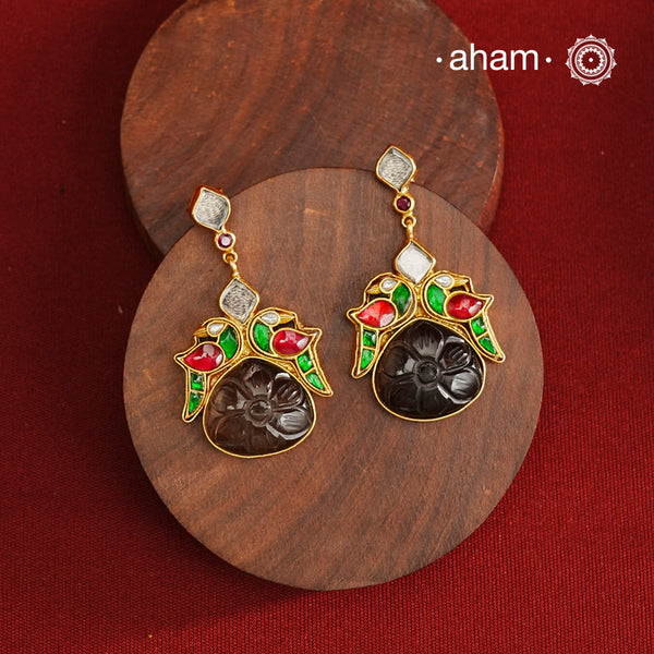 These exquisite earrings feature a carved black onyx center, elegantly framed by kundan parrots on each side. Crafted from 92.5% silver with a fine gold polish, they offer a perfect blend of traditional artistry and contemporary style. Ideal for mehandi and sangeet functions, these earrings add a sophisticated touch to festive attire while showcasing expert craftsmanship.