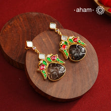 These exquisite earrings feature a carved black onyx center, elegantly framed by kundan parrots on each side. Crafted from 92.5% silver with a fine gold polish, they offer a perfect blend of traditional artistry and contemporary style. Ideal for mehandi and sangeet functions, these earrings add a sophisticated touch to festive attire while showcasing expert craftsmanship.