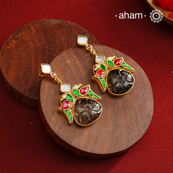 These exquisite earrings feature a carved black onyx center, elegantly framed by kundan parrots on each side. Crafted from 92.5% silver with a fine gold polish, they offer a perfect blend of traditional artistry and contemporary style. Ideal for mehandi and sangeet functions, these earrings add a sophisticated touch to festive attire while showcasing expert craftsmanship.