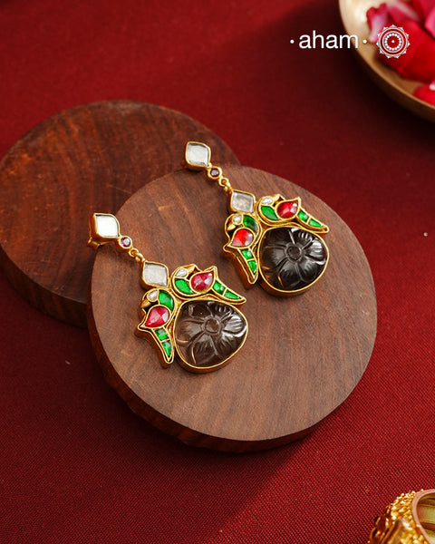 These exquisite earrings feature a carved black onyx center, elegantly framed by kundan parrots on each side. Crafted from 92.5% silver with a fine gold polish, they offer a perfect blend of traditional artistry and contemporary style. Ideal for mehandi and sangeet functions, these earrings add a sophisticated touch to festive attire while showcasing expert craftsmanship.