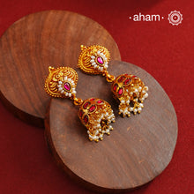 Traditional jhumkies showcasing exquisite Kemp work, meticulously crafted in 92.5% silver with a fine gold polish finish. Adorned with delicate pearls, they blend classic elegance with expert craftsmanship, making them a timeless addition to any jewelry collection.