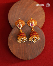 Traditional jhumkies showcasing exquisite Kemp work, meticulously crafted in 92.5% silver with a fine gold polish finish. Adorned with delicate pearls, they blend classic elegance with expert craftsmanship, making them a timeless addition to any jewelry collection.
