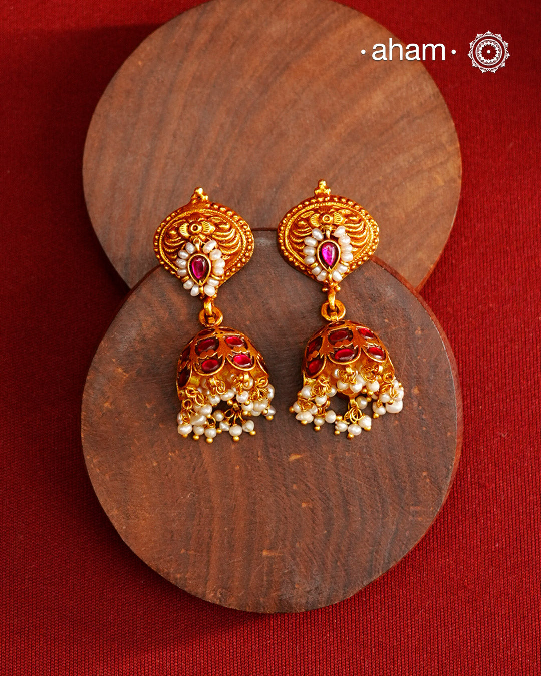 Traditional jhumkies showcasing exquisite Kemp work, meticulously crafted in 92.5% silver with a fine gold polish finish. Adorned with delicate pearls, they blend classic elegance with expert craftsmanship, making them a timeless addition to any jewelry collection.
