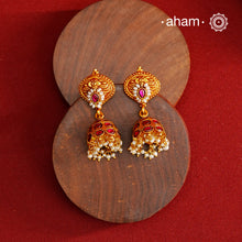 Traditional jhumkies showcasing exquisite Kemp work, meticulously crafted in 92.5% silver with a fine gold polish finish. Adorned with delicate pearls, they blend classic elegance with expert craftsmanship, making them a timeless addition to any jewelry collection.